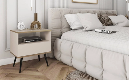 Luxusní béžový noční stolek se zásuvkou elegantní design skříňka doplněná zlatým lemováním skříňka stojí na černých kovových nožkách