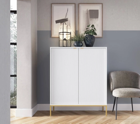Bílá komoda Lovro 104 cm v moderním designu obohacená o zlaté doplňky potěší milovníky výrazných interiérů