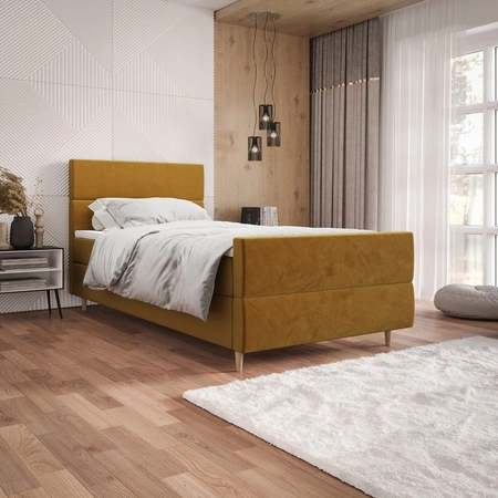 Kontinentální postel Benet 90x200 hořčice v moderním skandinávském stylu s čalouněným podhlavníkem a podnožkou s úložným boxem