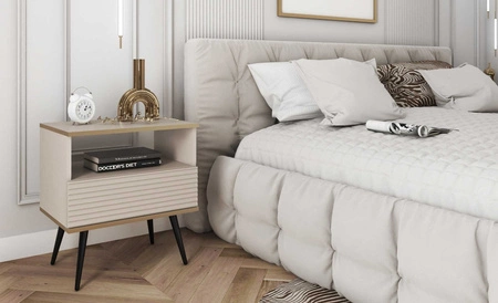 Luxusní béžový noční stolek se zásuvkou elegantní design skříňka se zlatým lemováním skříňka s rýhovaným čelem černé vysoké nohy