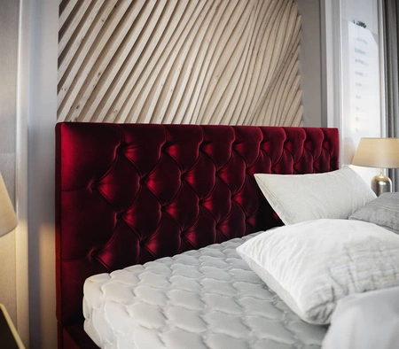 Čalouněná postel Viamao 180x200 bordó s kontejnerem v moderním skandinávském stylu s prošívaným čelem a nohama