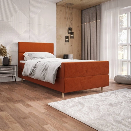 Kontinentální postel Benet 90x200 v cihlově červené barvě v moderním skandinávském stylu s čalouněným čelem a nohami postele s úložným boxem